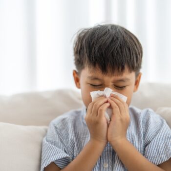 Young,Asian,Boy,Sneezing,Or,Blowing,His,Nose,And,Mouth
